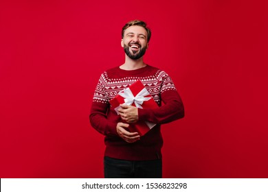 Laughing Glad Man With Beard Holding New Year Present. Studio Portrait Of White Guy Enjoying Christmas.