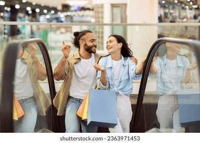 Laughing glad young european couple shopaholics with bags hugging, have fun, enjoy shopping and free time in mall. Lifestyle, sale and discount, love and relationships in city - Powered by Shutterstock