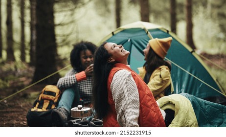 Laughing Group Of Diverse Young Female Friends Relaxing Together At Their Campsite In The Woods