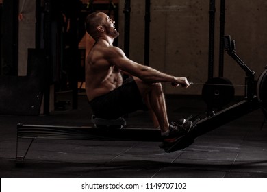 Laughing Guy Is Developing His Muscles With Indoor Rower.free Time And Hobby Concept