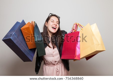 Laughing happu girl holds shopping bags