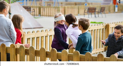 Laughing happy cheerful children playing at Blind man bluff outdoors