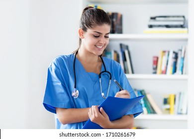 Laughing Hispanic Female Nurse At Work At Hospital