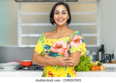 Laughing Hispanic Mother Or Housewife At Kitchen Indoors At Home