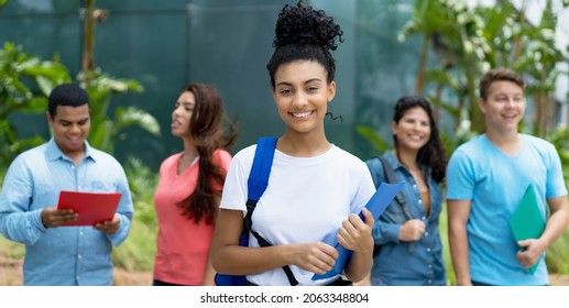 Laughing indian female student with group of multi ethnic young adults outdoor in city