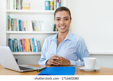 Laughing Latin American Businesswoman With Computer At Desk At Home Office