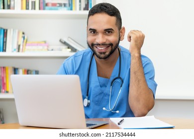 Laughing Latin American Medical Student At Computer At Hospital