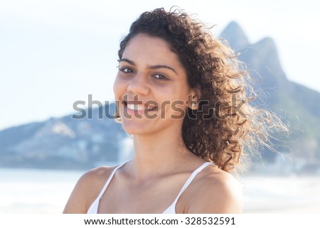 Laughing latin woman with curly hair at beach at Rio de Janeiro