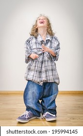 Laughing Little Girl In Oversized Jeans And Shirt.