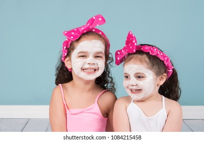 Laughing Little Girls In Beauty Face Masks And Polka Dot Headbands