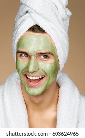 Laughing man with facial mask of avocado. Photo of Happy man smiling while wearing a facial mask. Beauty & Skin care concept
