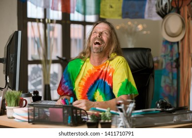 Laughing Man In Tie Dye Shirt At His Desk