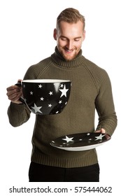 Laughing Man Wearing A Green Turtle Neck Sweater And Holding A Big Oversized Mug. Standing Against A White Background.