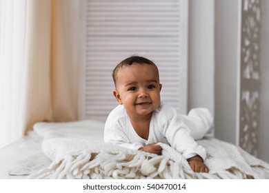 Laughing Mixed Race Baby Boy Lying On Tummy At Home