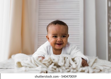 Laughing Mixed Race Baby Boy Lying On Tummy At Home