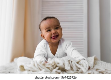 Laughing Mixed Race Baby Boy Lying On Tummy At Home