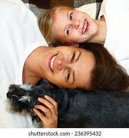laughing mother and daughter lying together on the plaid - Shutterstock ID 236395432