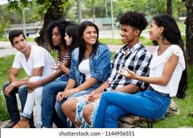 Laughing Native Latin American Woman And African Man Talking With Caucasian Friends Outdoor In The Summer In The City