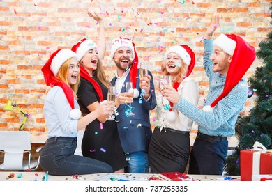 Laughing Office Workers Throwing Beautiful Confetti On A Blurred Background. Christmas Confetti Concept.