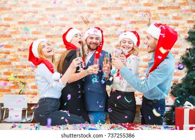 Laughing Office Workers Throwing Beautiful Confetti On A Blurred Background. Christmas Confetti Concept.