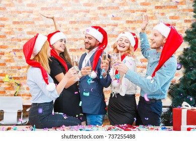 Laughing Office Workers Throwing Beautiful Confetti On A Blurred Background. Christmas Confetti Concept.