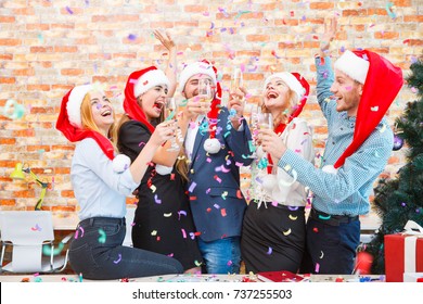 Laughing Office Workers Throwing Beautiful Confetti On A Blurred Background. Christmas Confetti Concept.