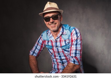 Laughing Old Man In Casual Clothes And Sunglasses Sitting In Studio With Hap On