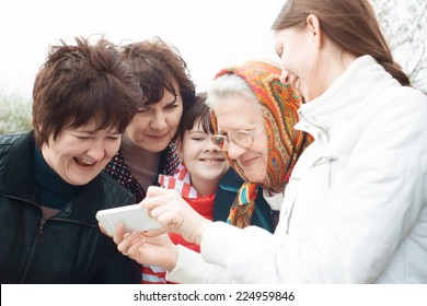 Laughing People Look At Mobile Phone. Emotional Group Portrait. Women Of All Ages