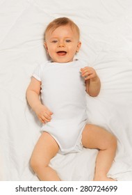 Laughing small baby wearing white bodysuit