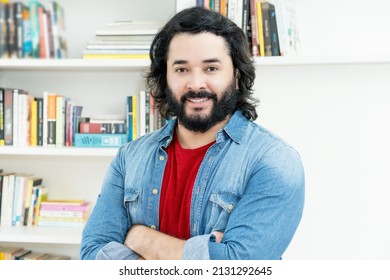 Laughing strong man with full beard indoors at home