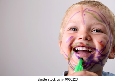 Laughing Toddler Playing With Colored Pens Making A Mess