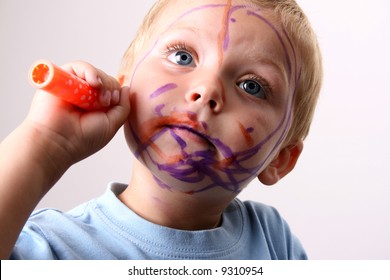 Laughing Toddler Playing With Colored Pens Making A Mess