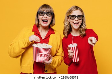 Laughing Woman 50s With Teenager Girl 12-13 Years Old In 3d Glasses Watch Movie Film Hold Bucket Of Popcorn Cup Of Soda Isolated On Plain Yellow Background. People Emotions In Cinema Lifestyle Concept