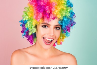 Laughing woman in colorful wig licking tongue lips. Funny woman face close up. Crazy girl studio portrait. Lips fun.