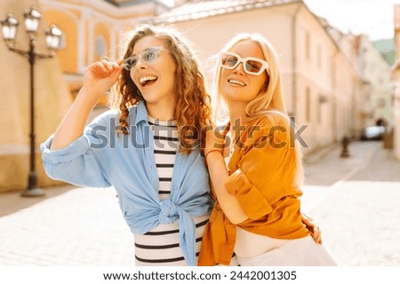 Laughing woman enjoying weekend together. Two young women fooling around in fresh air. Summer playful mood concept