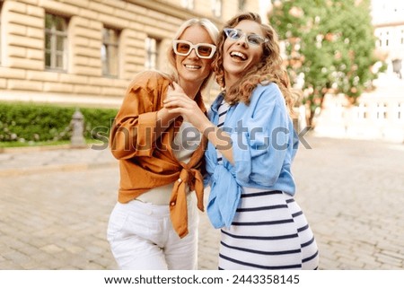 Laughing woman enjoying weekend together. Two young women fooling around in fresh air. Summer playful mood concept