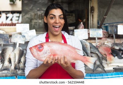Laughing woman selling fresh fish on a latin fish market