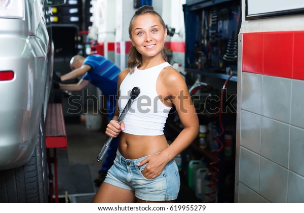 Laughing woman\
working in car workshop\
indoors
