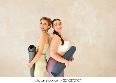 Laughing Women Posing After Yoga. Female Friends Laughing And Holding Yoga Mats After Yoga Session Together At Home. Attractive Girls In Sportswear Spending Free Leisure Time - Powered by Shutterstock