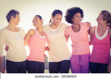 Femmes en train de rire vêtues de rose pour le cancer du sein dans un parc