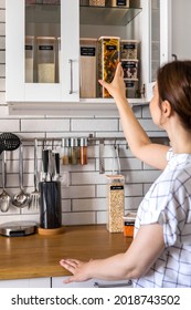 Laughing Young Female Housewife Posing During General Cleaning, Tidying Up In Cupboard Kitchen. Woman Placing, Sorting Food Into Pp Boxes For Comfortable Storage At Cuisine Having Positive Emotion