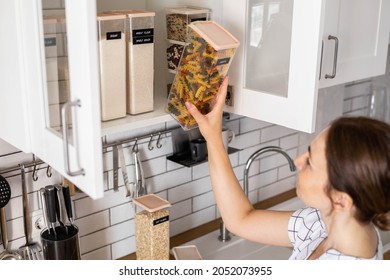 Laughing Young Female Housewife Posing During General Cleaning, Tidying Up In Cupboard Kitchen. Woman Placing, Sorting Food Into Pp Boxes For Comfortable Storage At Cuisine Having Positive Emotion