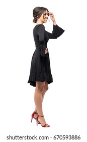 Laughing Young Latin Woman In Black Dress Looking Away. Side View.  Full Body Length Portrait Isolated On White Studio Background. 