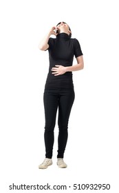 Laughing Young Woman On The Cellphone Holding Stomach With Head Back. Full Body Length Portrait Isolated Over White Studio Background.