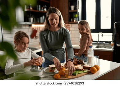  Laughter echoes in the kitchen as mother and daughters squeeze oranges, creating a refreshing touch to their delightful breakfast. - Powered by Shutterstock