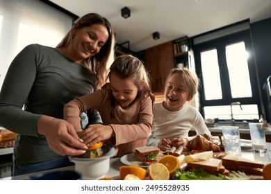  Laughter echoes in the kitchen as mother and daughters squeeze oranges, creating a refreshing touch to their delightful breakfast. - Powered by Shutterstock