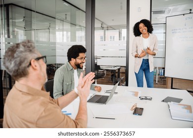 Laughter fills a modern office as colleagues share a joyous moment, the open space and casual attire highlighting a relaxed, yet productive, work culture. - Powered by Shutterstock