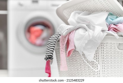 Laundry In A Basket For Dirty Clothes On The Background Of A Washing Machine.