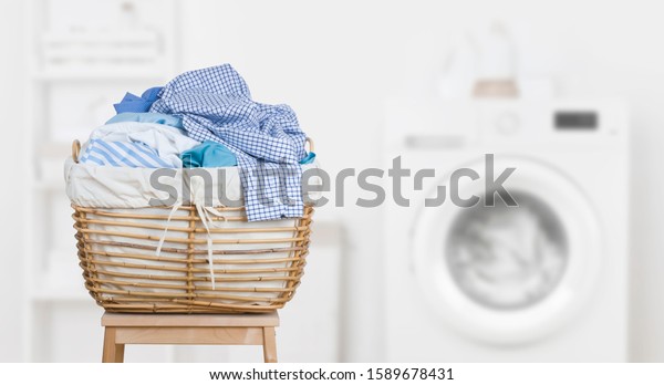 Laundry basket on blurred background of modern\
washing machine