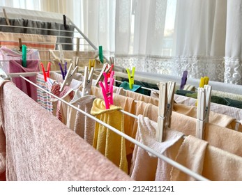 laundry, Laundry or clean wet clothes and towels hanging with colorful plastic clothespins on clothesline to dry in room, home interior. hanged clothes with selective focus on clothesline